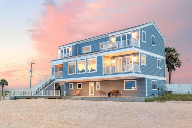 view of front of property with a patio area, a balcony, and fence