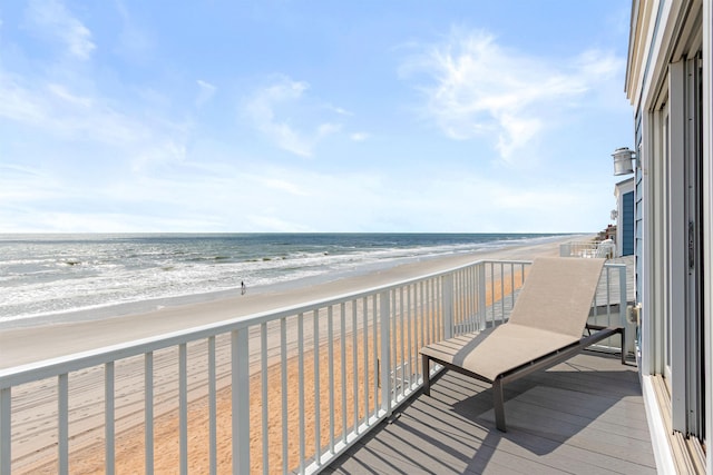 balcony featuring a water view and a beach view