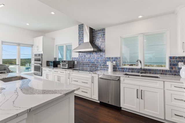 kitchen with a sink, wall chimney exhaust hood, tasteful backsplash, and stainless steel appliances