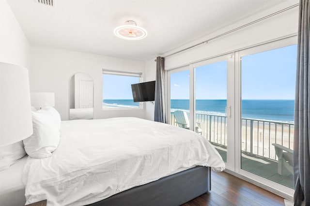 bedroom with visible vents, multiple windows, dark wood-style floors, and access to outside