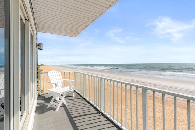 balcony featuring a view of the beach and a water view