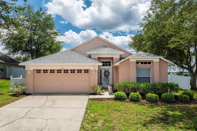 1505 Sundown Ln, Clermont, FL 34711 - view of front facade with a garage, stucco siding, driveway, and a shingled roof