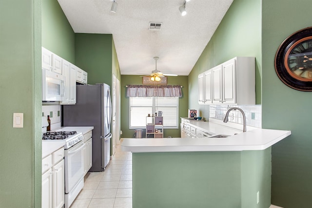 1505 Sundown Ln, Clermont, FL 34711 - kitchen with white appliances, a sink, light countertops, vaulted ceiling, and a textured ceiling