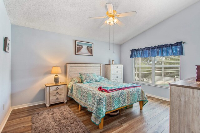 1505 Sundown Ln, Clermont, FL 34711 - bedroom featuring a textured ceiling, wood finished floors, baseboards, lofted ceiling, and ceiling fan