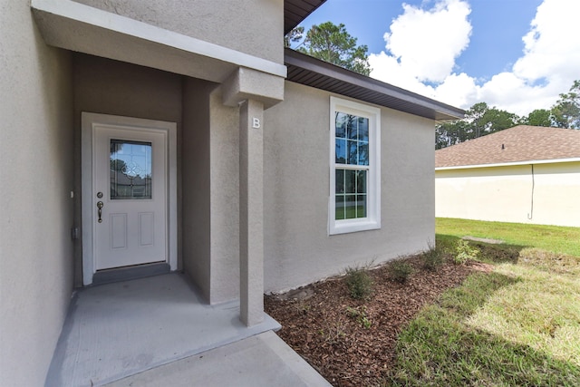 view of exterior entry featuring a yard