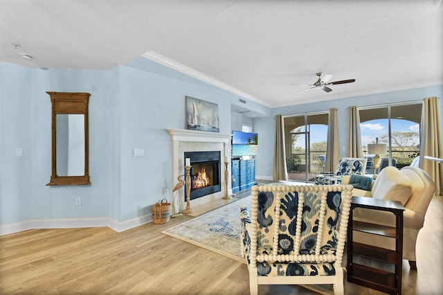 living room featuring a textured ceiling, hardwood / wood-style flooring, ceiling fan, and ornamental molding