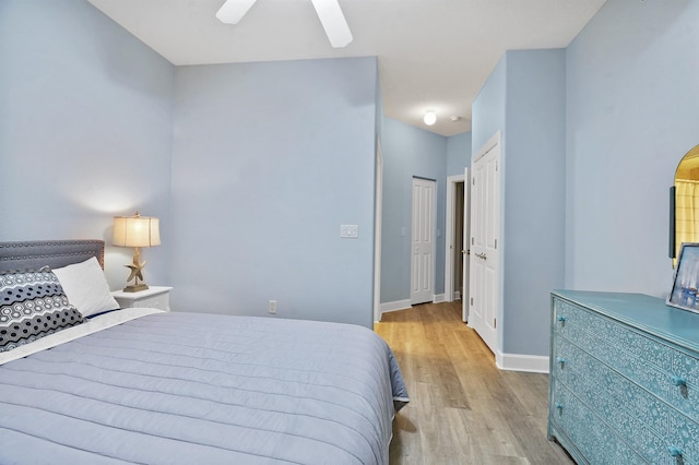 bedroom with ceiling fan, a closet, and light hardwood / wood-style floors