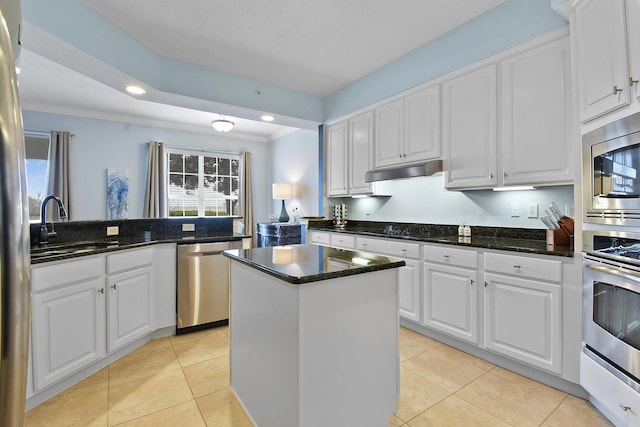 kitchen featuring white cabinets, a center island, ornamental molding, and stainless steel appliances