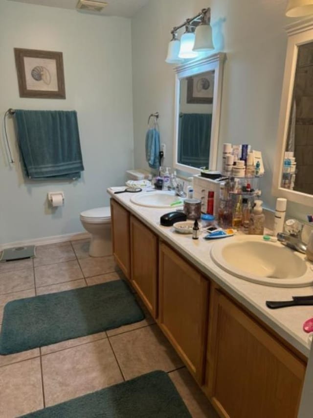 bathroom featuring toilet, vanity, and tile patterned floors