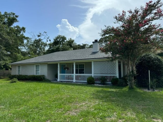 back of property with a yard and a porch