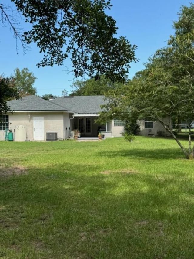 back of house featuring a lawn and central AC