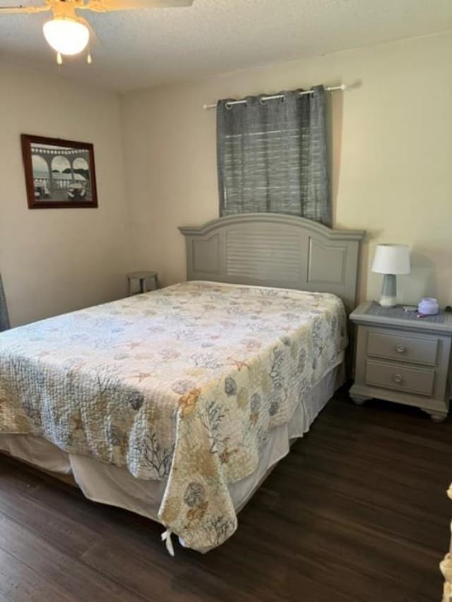 bedroom with dark hardwood / wood-style flooring and ceiling fan