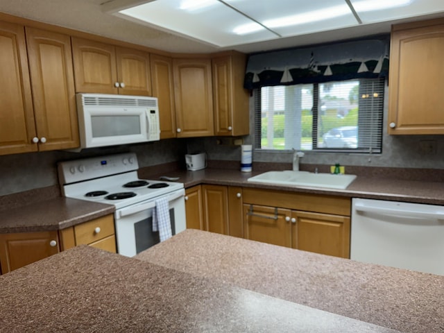 kitchen featuring sink, white appliances, and decorative backsplash