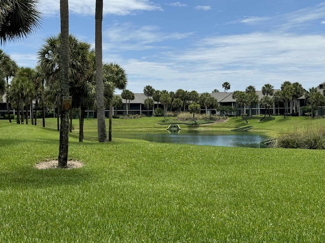 view of property's community featuring a lawn and a water view