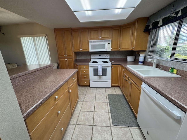 kitchen featuring sink, white appliances, light tile patterned floors, and tasteful backsplash