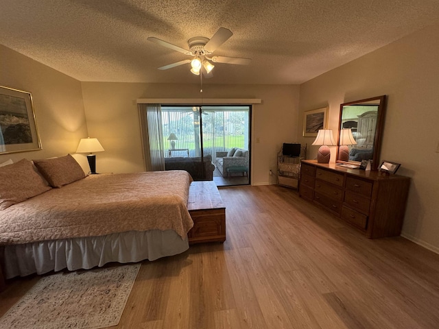 bedroom featuring a textured ceiling, access to exterior, light hardwood / wood-style flooring, and ceiling fan