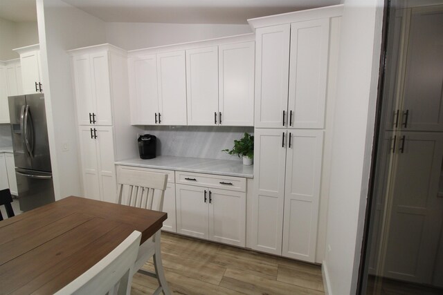 24 Aledo Ct, Saint Augustine, FL 32086 - kitchen with tasteful backsplash, lofted ceiling, light countertops, white cabinetry, and refrigerator with ice dispenser
