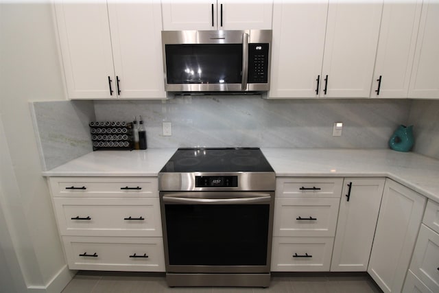 24 Aledo Ct, Saint Augustine, FL 32086 - kitchen featuring tile patterned flooring, stainless steel appliances, light countertops, white cabinetry, and backsplash