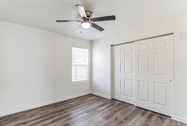 unfurnished bedroom with ceiling fan, a closet, a textured ceiling, and light wood-type flooring