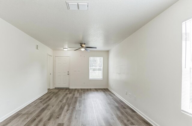 interior space featuring a textured ceiling, light hardwood / wood-style flooring, and ceiling fan