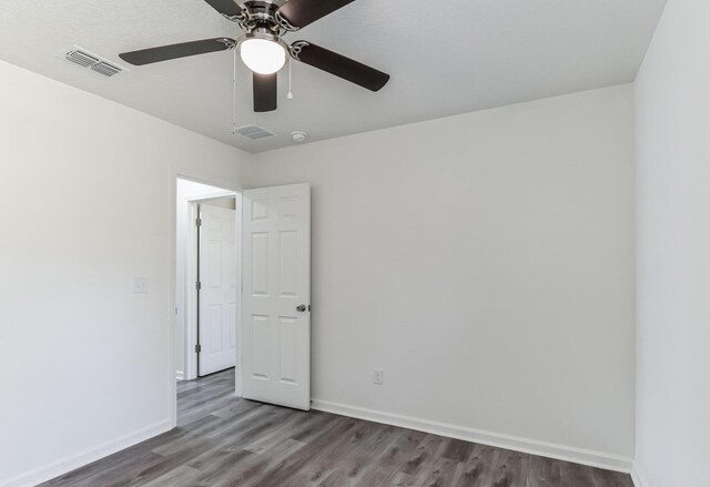 spare room with hardwood / wood-style floors and ceiling fan