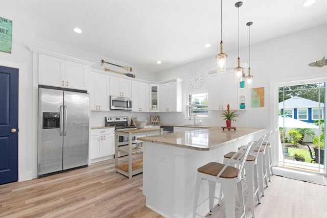 13 Court Edna, Saint Augustine, FL 32084 - kitchen featuring stainless steel appliances, white cabinetry, light wood finished floors, a peninsula, and recessed lighting
