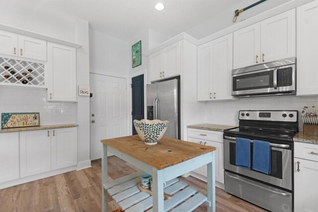 13 Court Edna, Saint Augustine, FL 32084 - kitchen featuring appliances with stainless steel finishes, white cabinetry, tasteful backsplash, and light wood finished floors