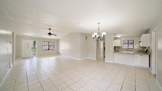 90 Wellshire Ln, Palm Coast, FL 32164 - unfurnished living room featuring a sink, a textured ceiling, ceiling fan with notable chandelier, baseboards, and light tile patterned floors