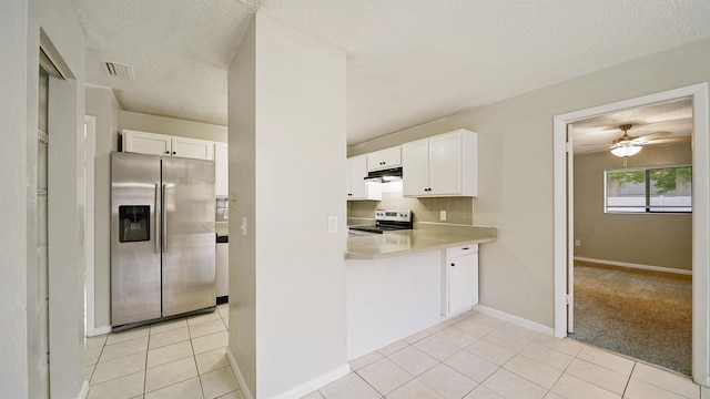 90 Wellshire Ln, Palm Coast, FL 32164 - kitchen with visible vents, light countertops, under cabinet range hood, white cabinets, and stainless steel appliances