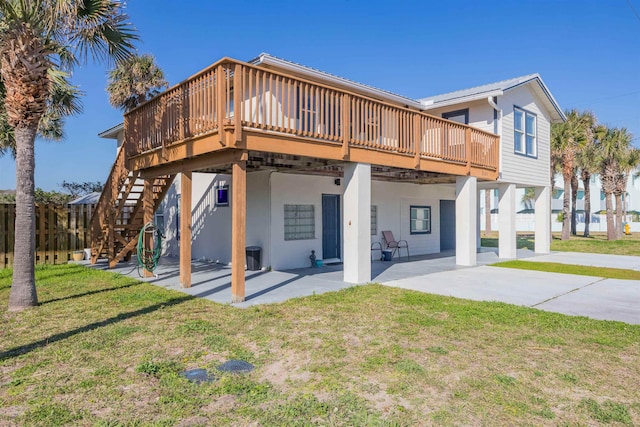 back of house with a wooden deck, a yard, and a patio area