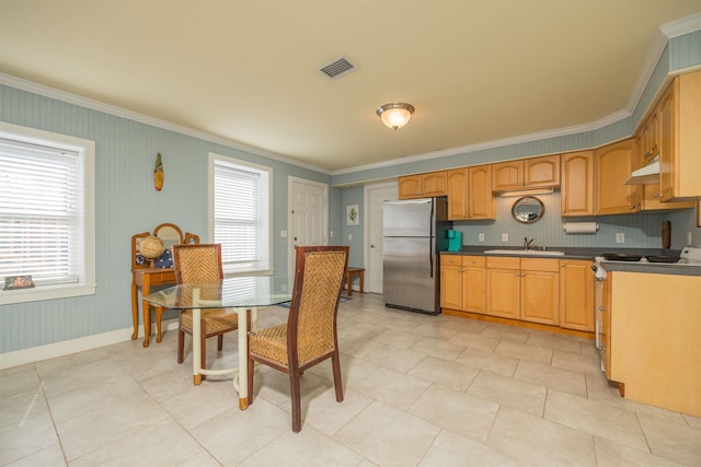 kitchen featuring range, stainless steel fridge, crown molding, and a wealth of natural light