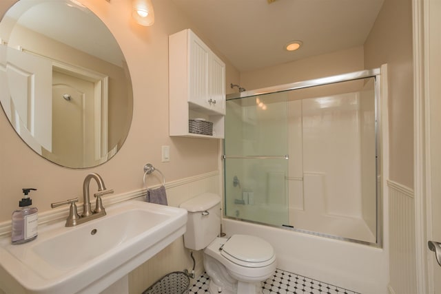 full bathroom featuring sink, enclosed tub / shower combo, and toilet