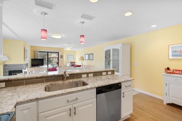 kitchen with a sink, visible vents, open floor plan, hanging light fixtures, and stainless steel dishwasher