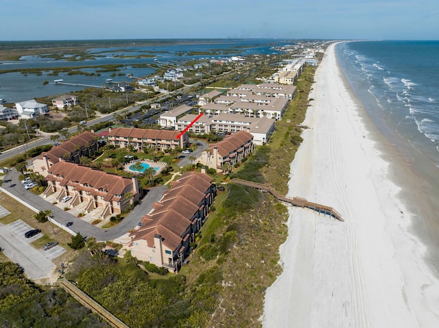 birds eye view of property with a water view and a beach view