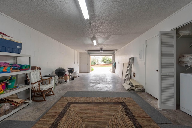 garage featuring concrete block wall and washer / clothes dryer