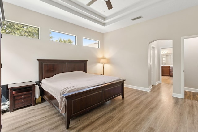 153 Savanna Preserve Ct, Saint Augustine, FL 32095 - bedroom featuring arched walkways, light wood finished floors, baseboards, a tray ceiling, and a ceiling fan