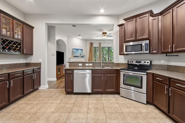153 Savanna Preserve Ct, Saint Augustine, FL 32095 - kitchen with stainless steel appliances, a sink, arched walkways, a peninsula, and a ceiling fan