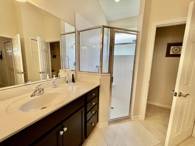 bathroom featuring vaulted ceiling, vanity, tile patterned flooring, and a shower with door