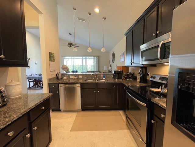 kitchen featuring sink, dark stone counters, hanging light fixtures, kitchen peninsula, and stainless steel appliances