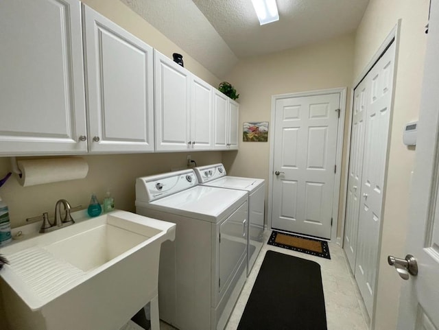 clothes washing area featuring cabinets, washing machine and clothes dryer, and sink