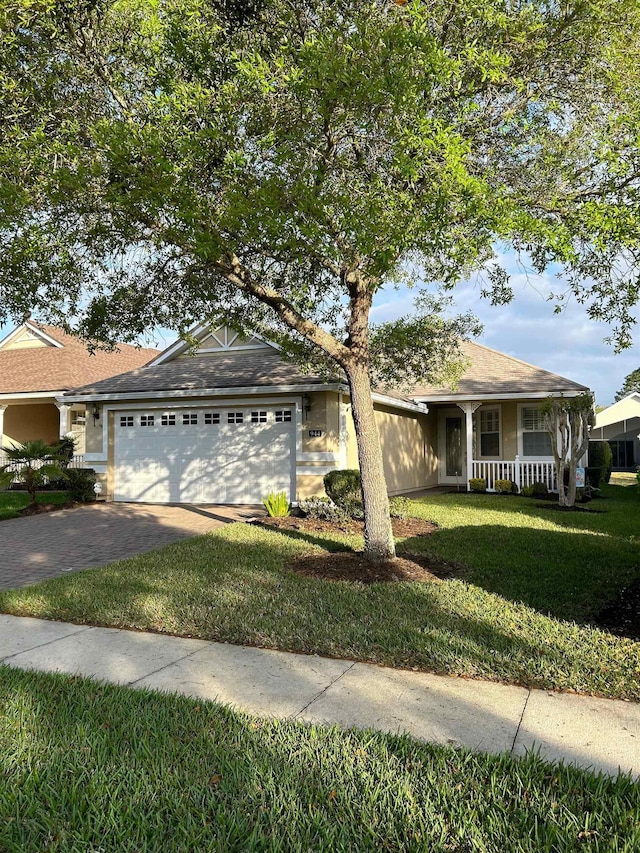 single story home with a garage, a front lawn, and a porch