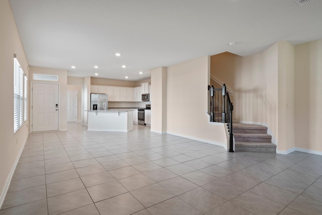 unfurnished living room with a wealth of natural light and light tile patterned floors