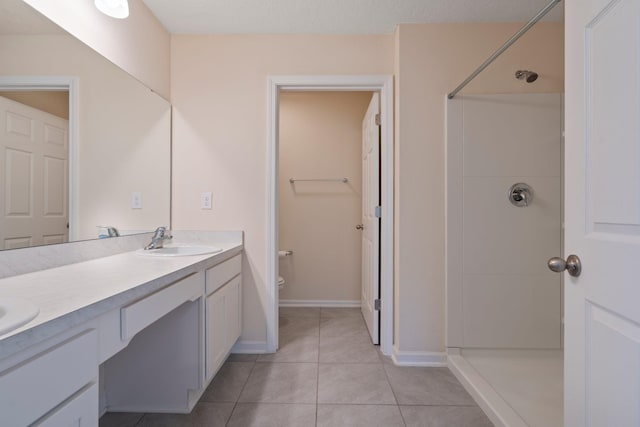 bathroom with toilet, vanity, tile patterned floors, and walk in shower