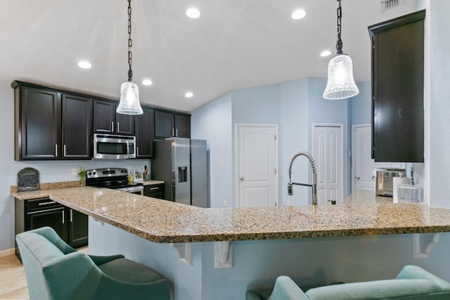 132 Fallen Timber Way, Saint Augustine, FL 32084 - kitchen featuring appliances with stainless steel finishes, light stone countertops, a breakfast bar area, a peninsula, and hanging light fixtures