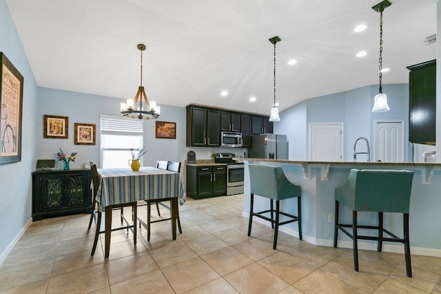132 Fallen Timber Way, Saint Augustine, FL 32084 - kitchen with appliances with stainless steel finishes, a chandelier, a breakfast bar, vaulted ceiling, and hanging light fixtures