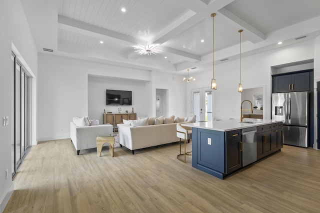 1 Clementon Ln, Palm Coast, FL 32137 - kitchen featuring stainless steel appliances, light wood-style flooring, a kitchen bar, light countertops, and an island with sink