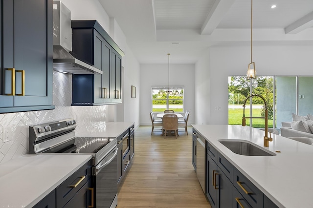 1 Clementon Ln, Palm Coast, FL 32137 - kitchen featuring appliances with stainless steel finishes, wall chimney range hood, decorative backsplash, light wood-type flooring, and light countertops