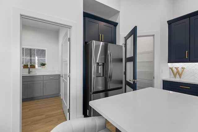 1 Clementon Ln, Palm Coast, FL 32137 - kitchen with stainless steel fridge, decorative backsplash, light wood-style floors, and light countertops