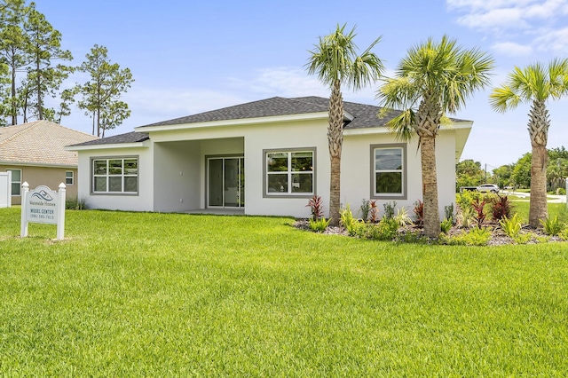 1 Clementon Ln, Palm Coast, FL 32137 - back of property featuring stucco siding, a lawn, and roof with shingles