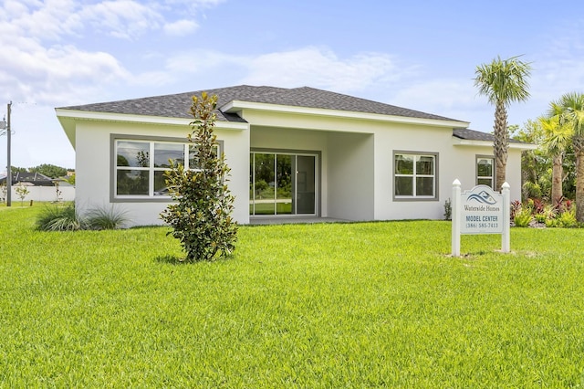 1 Clementon Ln, Palm Coast, FL 32137 - back of property with stucco siding, a yard, and roof with shingles
